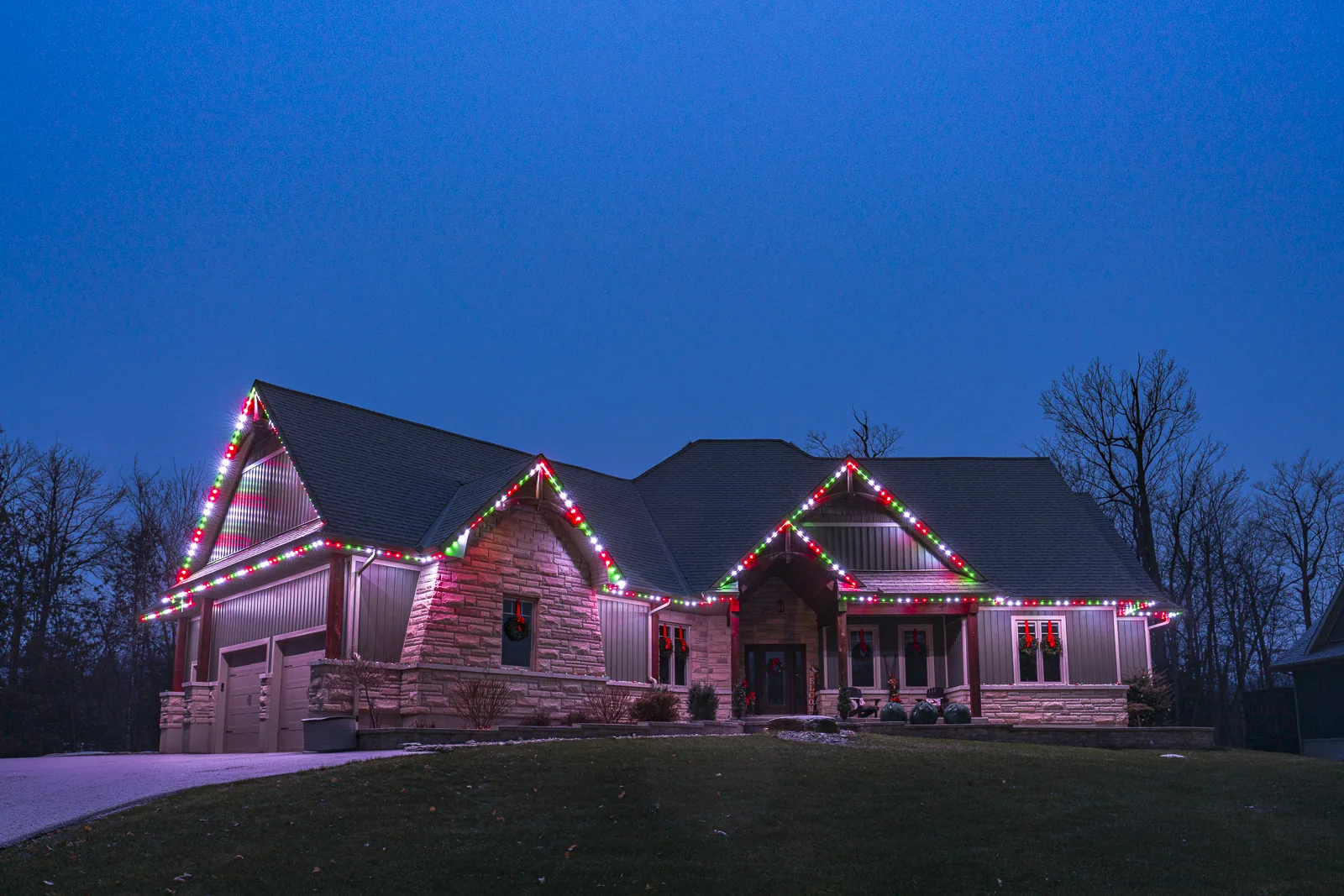 Gables outlined in red, green and white permanent lights at dusk