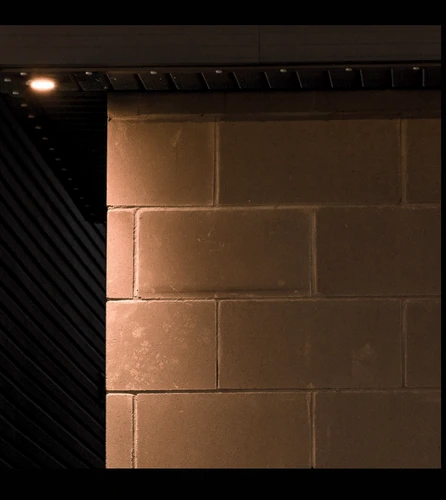 Downlight mounted outside the corner of a block wall