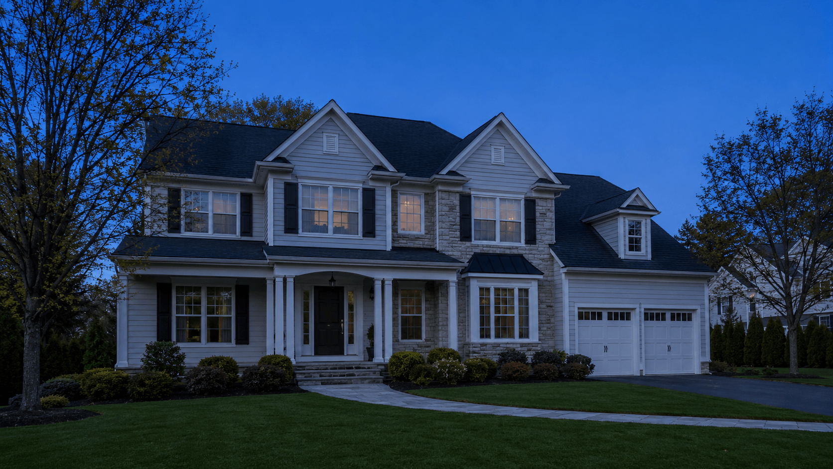 Lighting concept sequence on a sample colonial home: shown unlit, then washed in warm landscape lighting across its trees, beds, and walkway